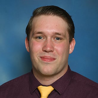 a person in a purple shirt and yellow tie