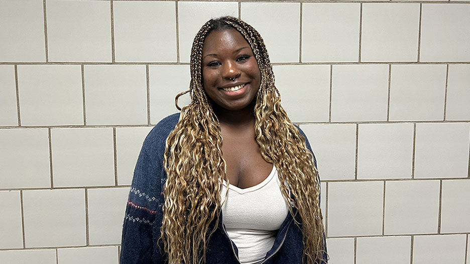 a person with long blonde hair and piercings smiling