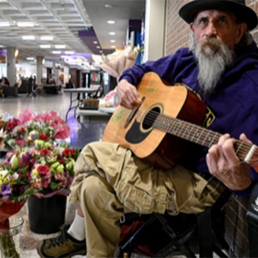 a person sitting on the ground playing a guitar