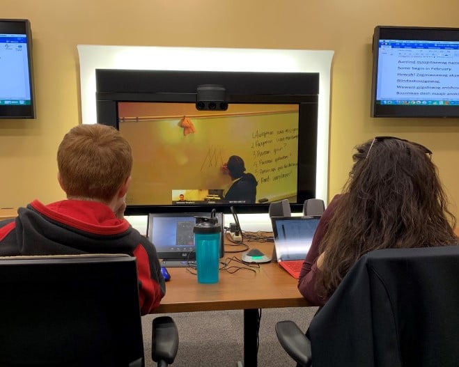 a group of people sitting at a table with computers