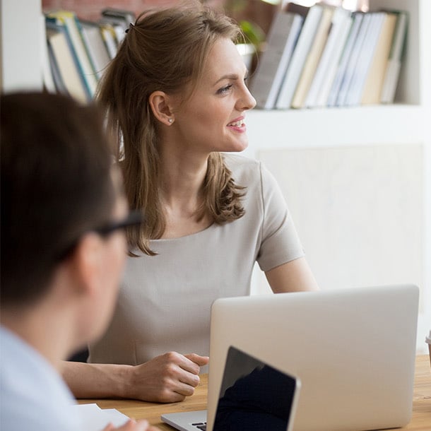 a person sitting at a table with a laptop