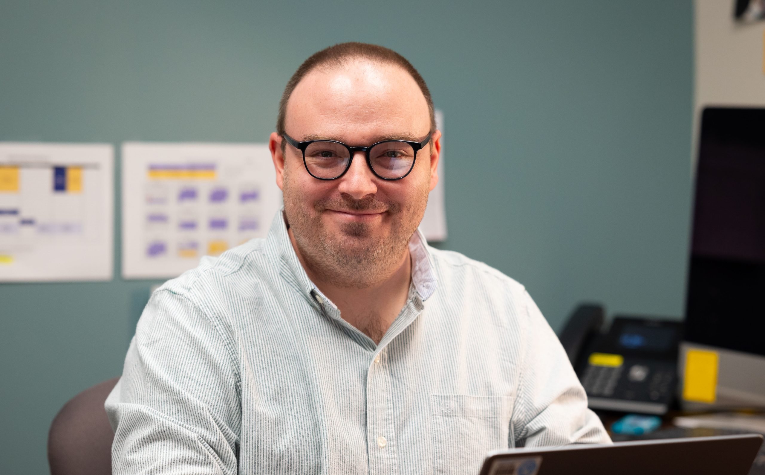 a person wearing glasses and smiling