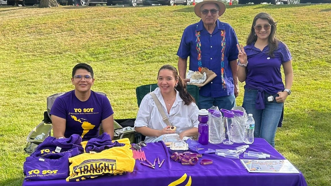 a group of people standing next to a table with items on it