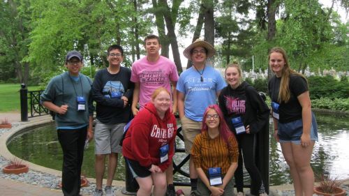 A group of students posing in front of a small fountain