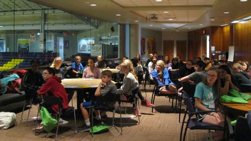 a group of kids sitting down and listening to something attentively in the Taylor Center