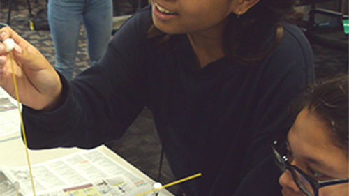 ETS students working on a project involving sticks and marshmellows