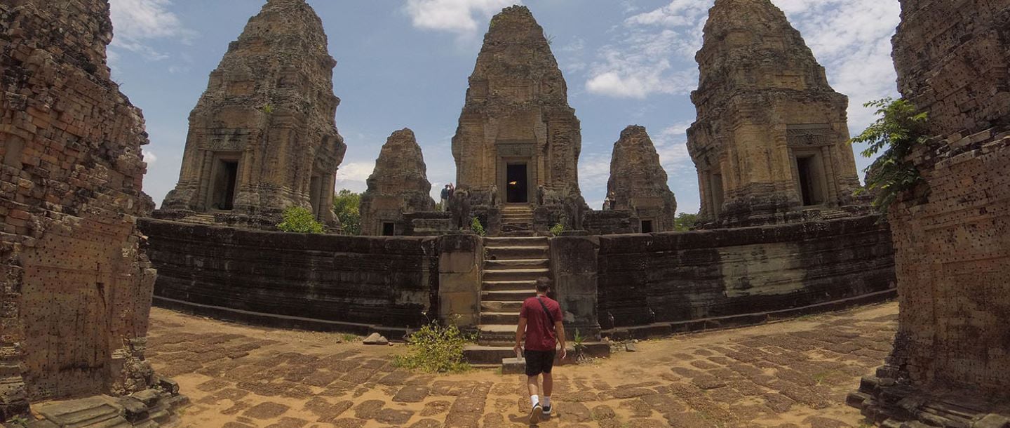 A student tourist walking towards an ancient ruins site