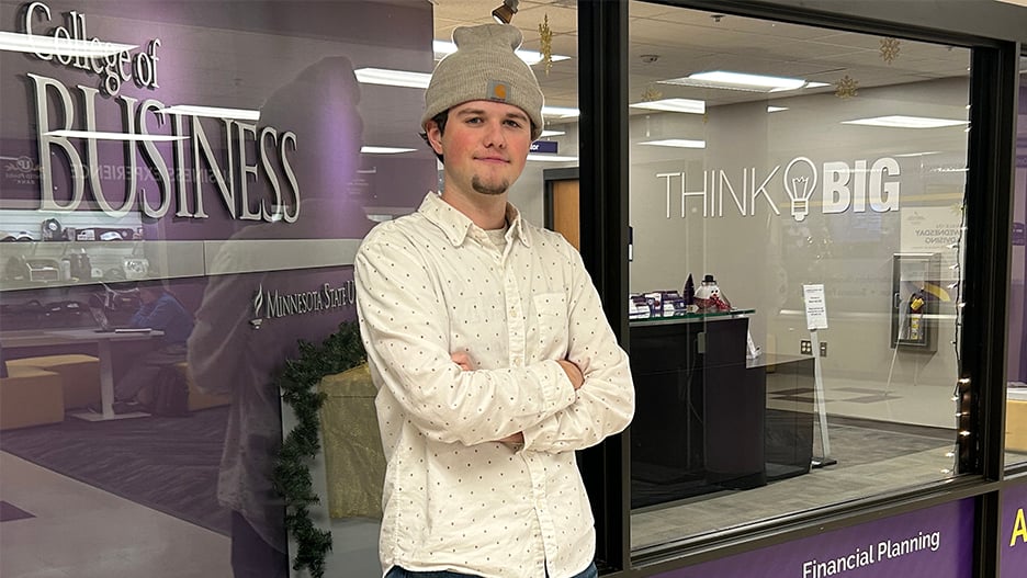 a person wearing a beanie and standing in front of a store