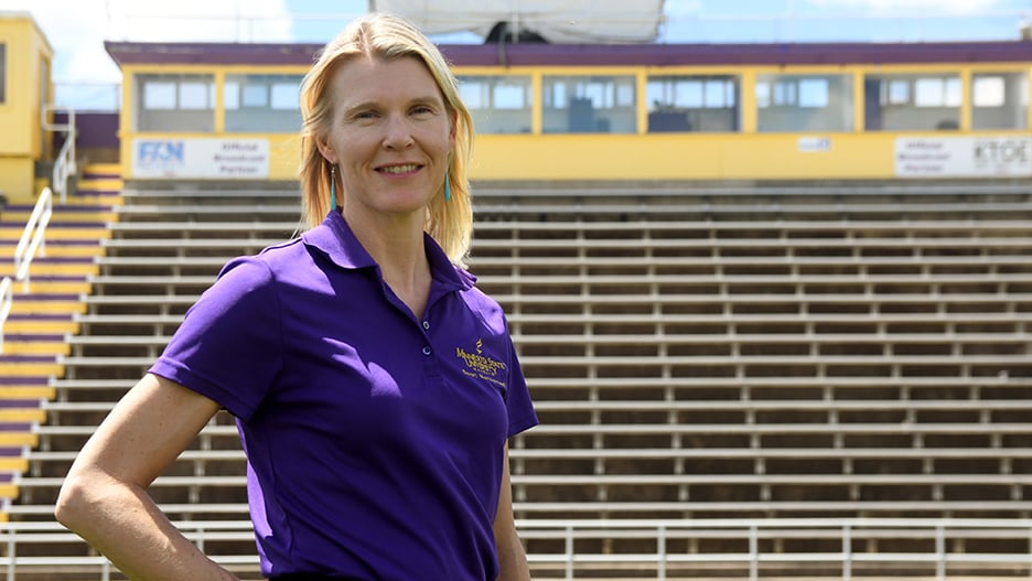 Director of the University’s sport management program, Suzannah Armentrout, posing outside on the Maverick football field