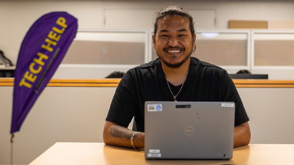 a person sitting at a table with a laptop