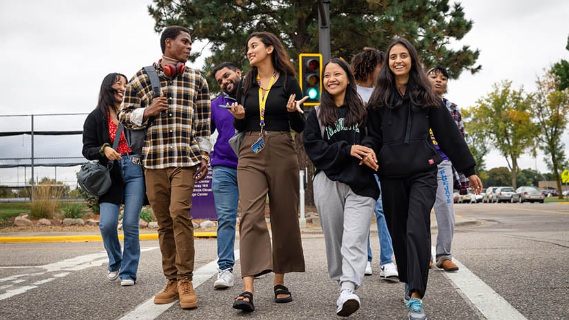 A group of international students crossing the street near campus laughing and engaging with each other