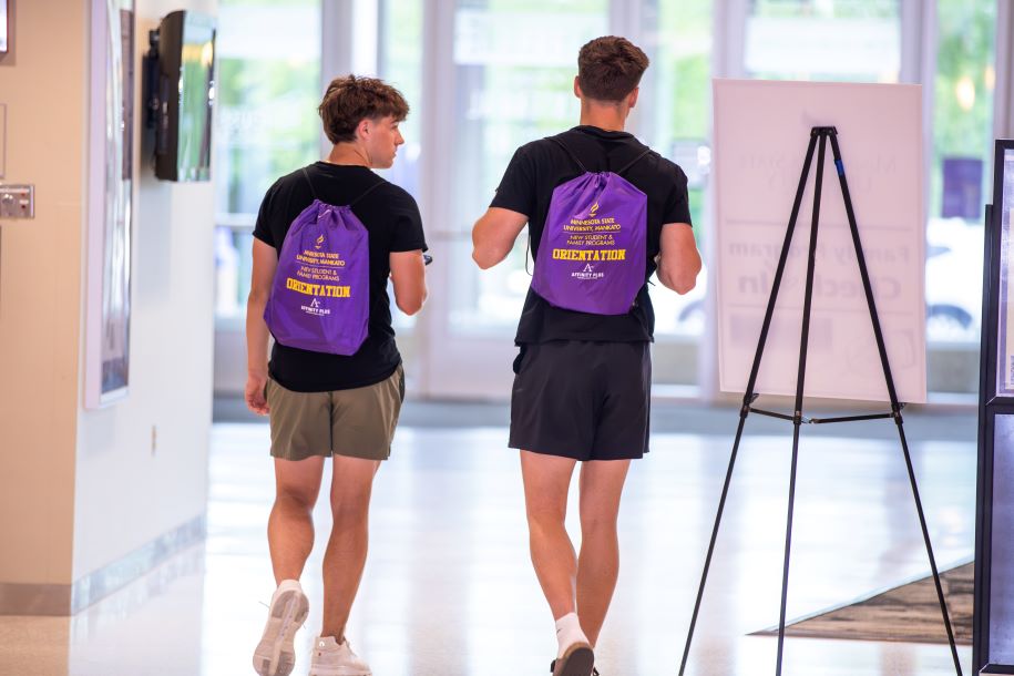 two men walking in a hallway