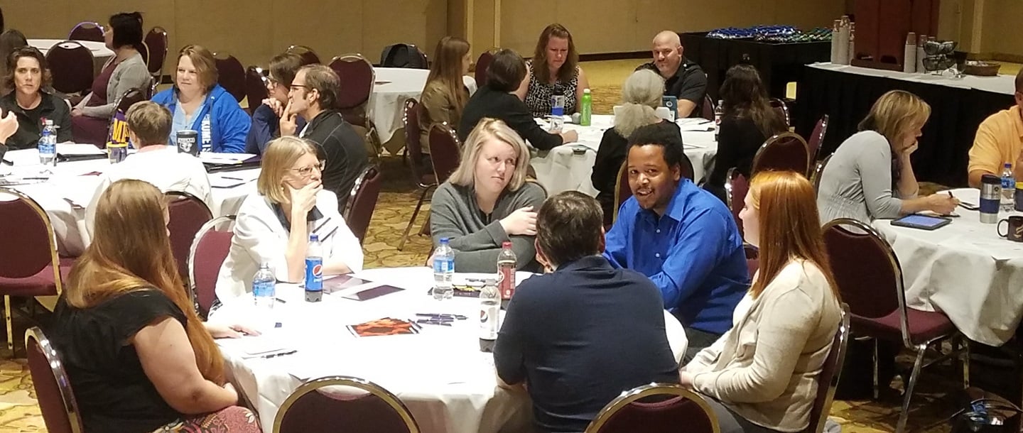 PSEO high school partners and MNSU faculty members having discussion in multiple group of six 